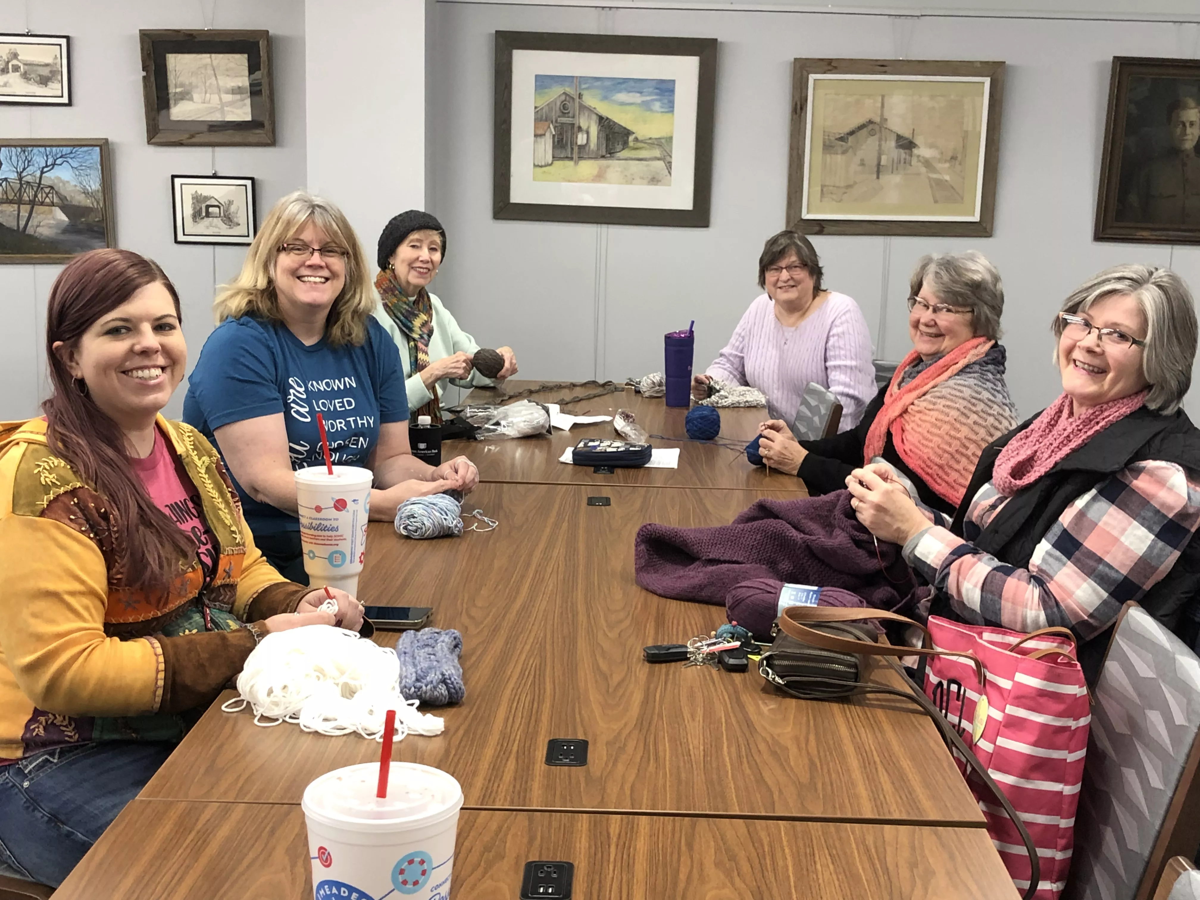 women sitting around table knitting