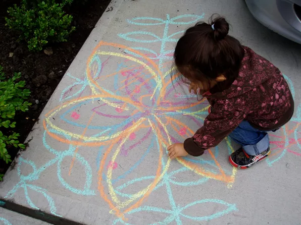 girl draws with chalk