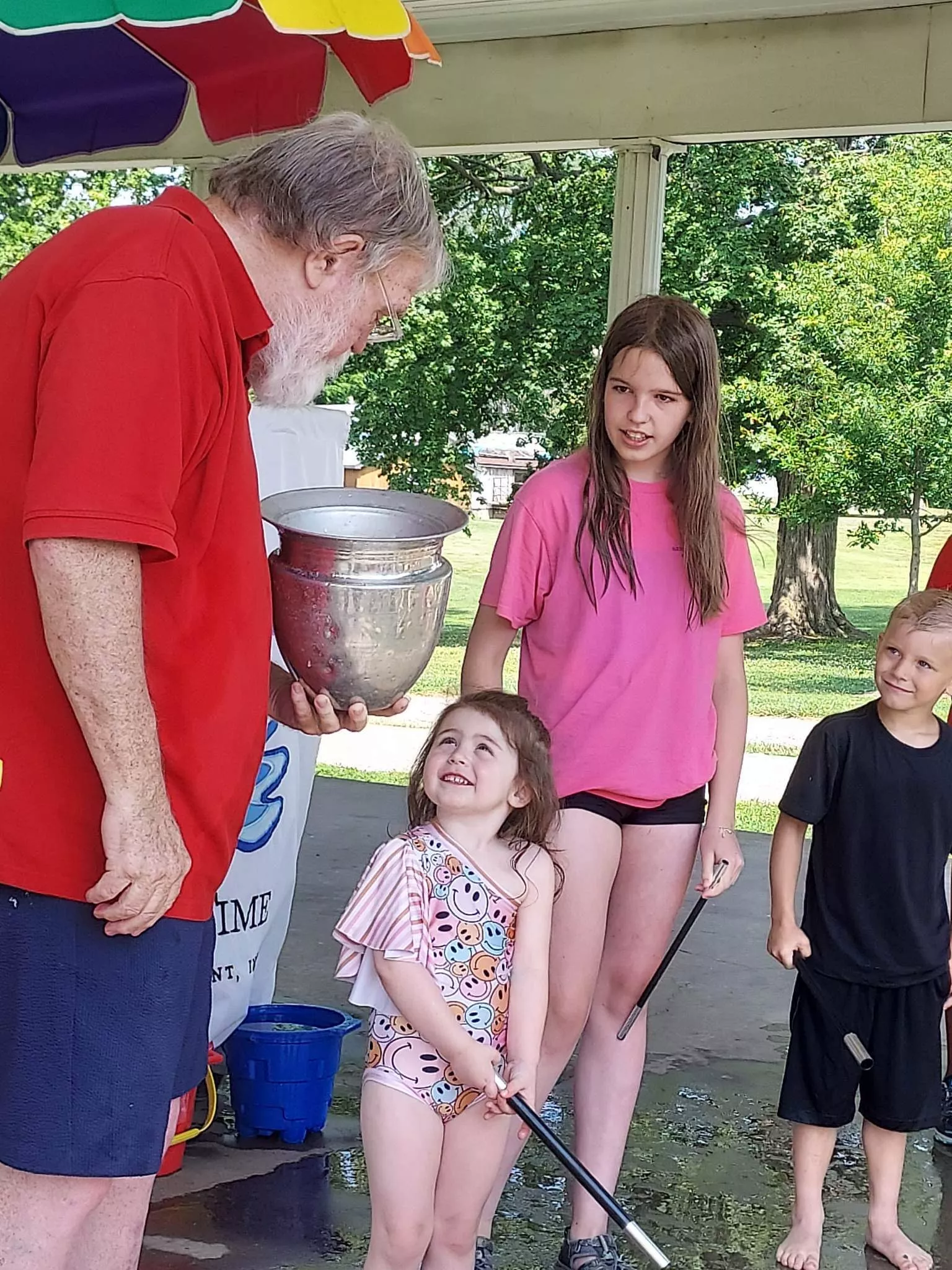 kids smiling at man with magic wand