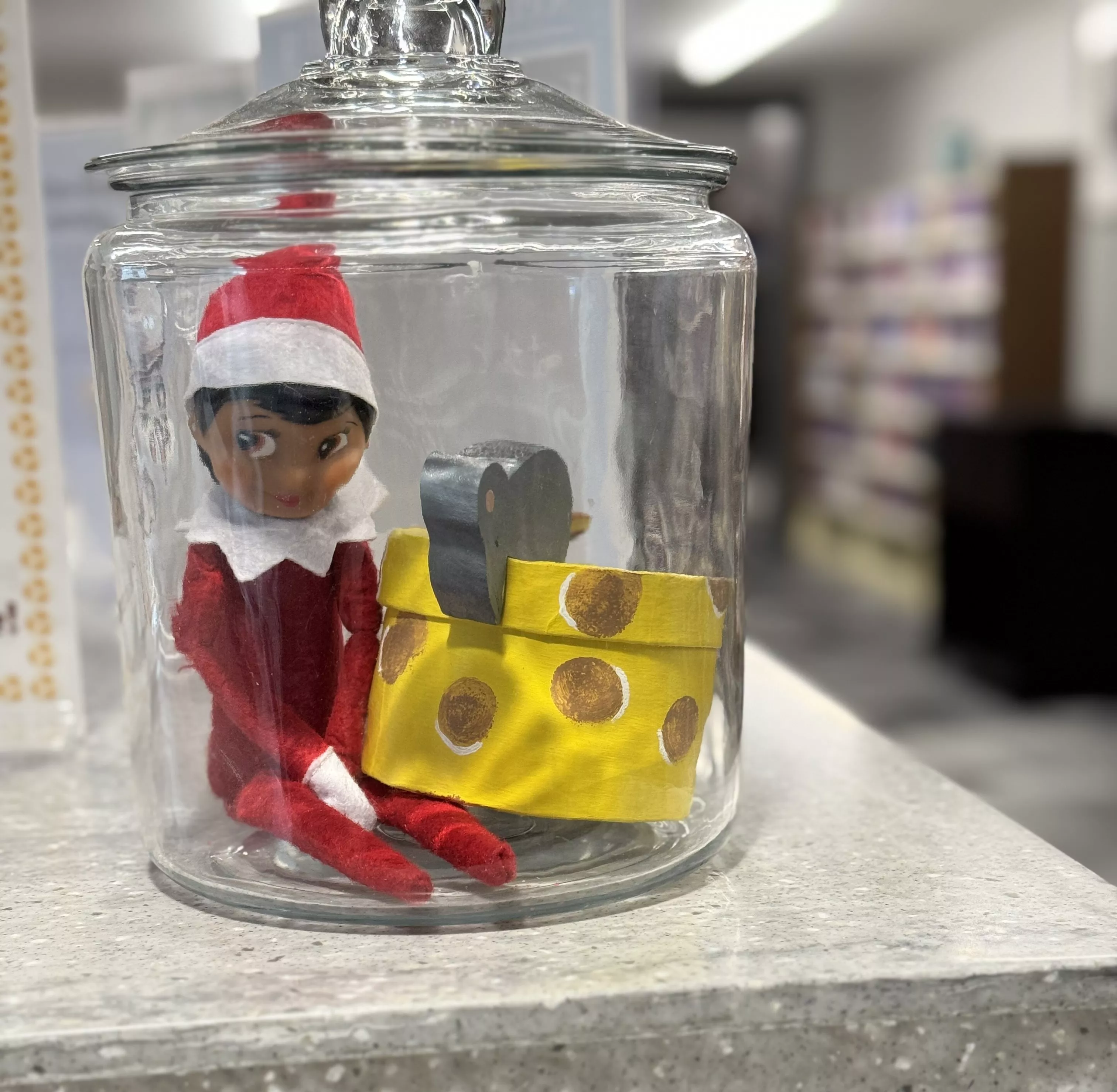 elf on the shelf elf in clear cookie jar with wooden mouse and cheese