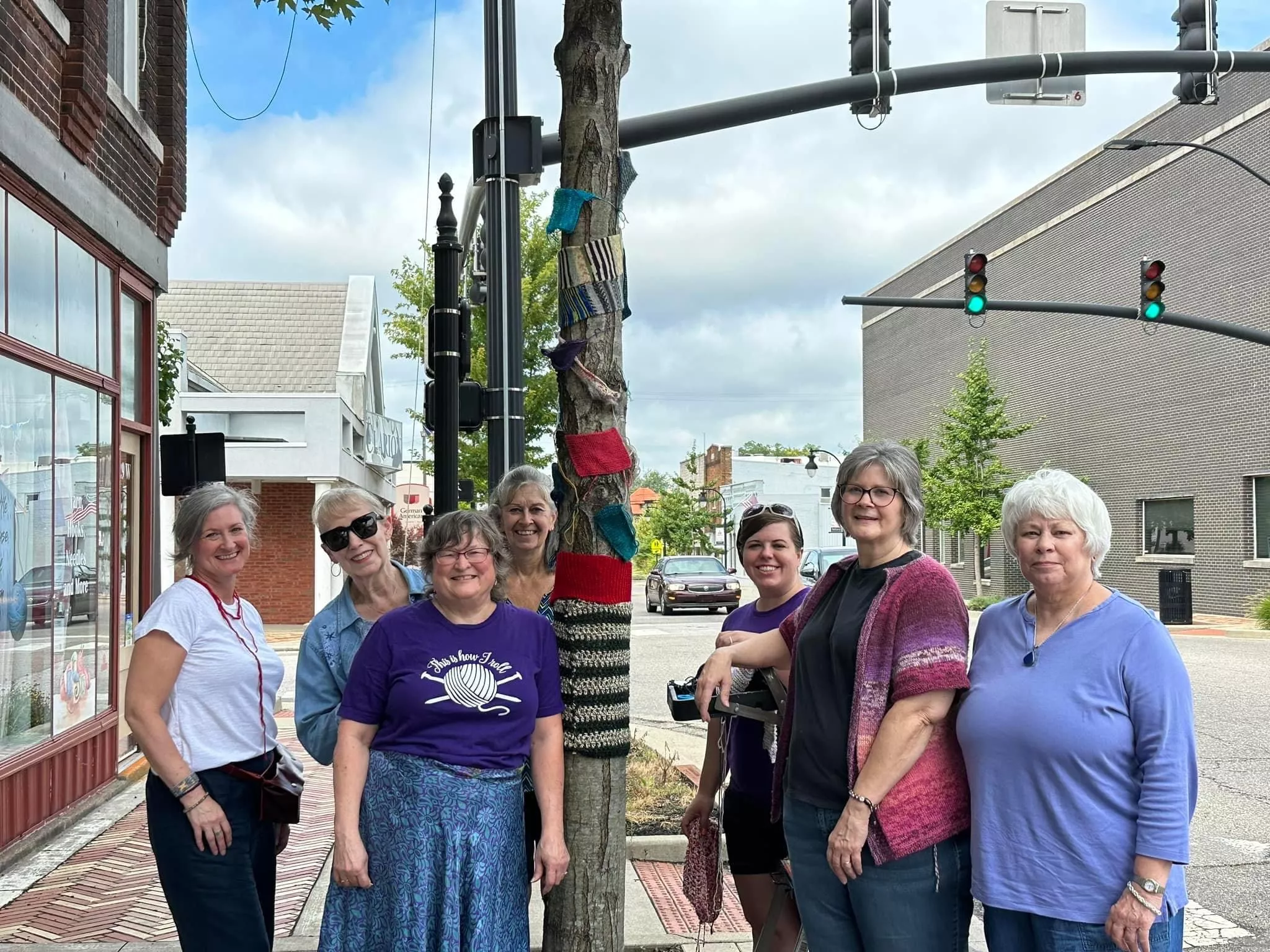 ladies around a yarn wrapped tree