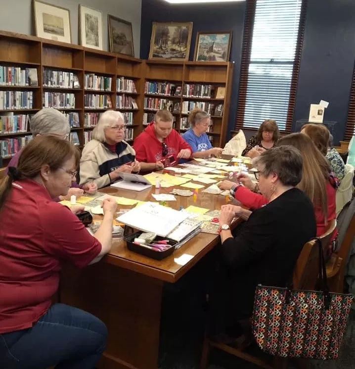 several ladies around a table quilting